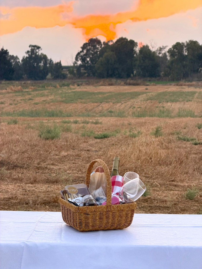 מארז Sunrise — סלסלת פיקניק על שולחן לבן בשקיעה